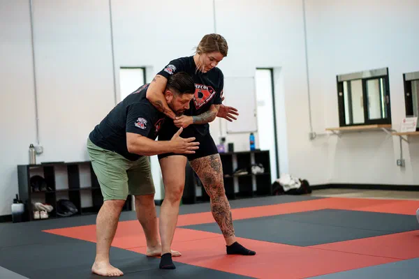 Coach showing Madison adult how to counter a headlock during self-defense fundamentals class