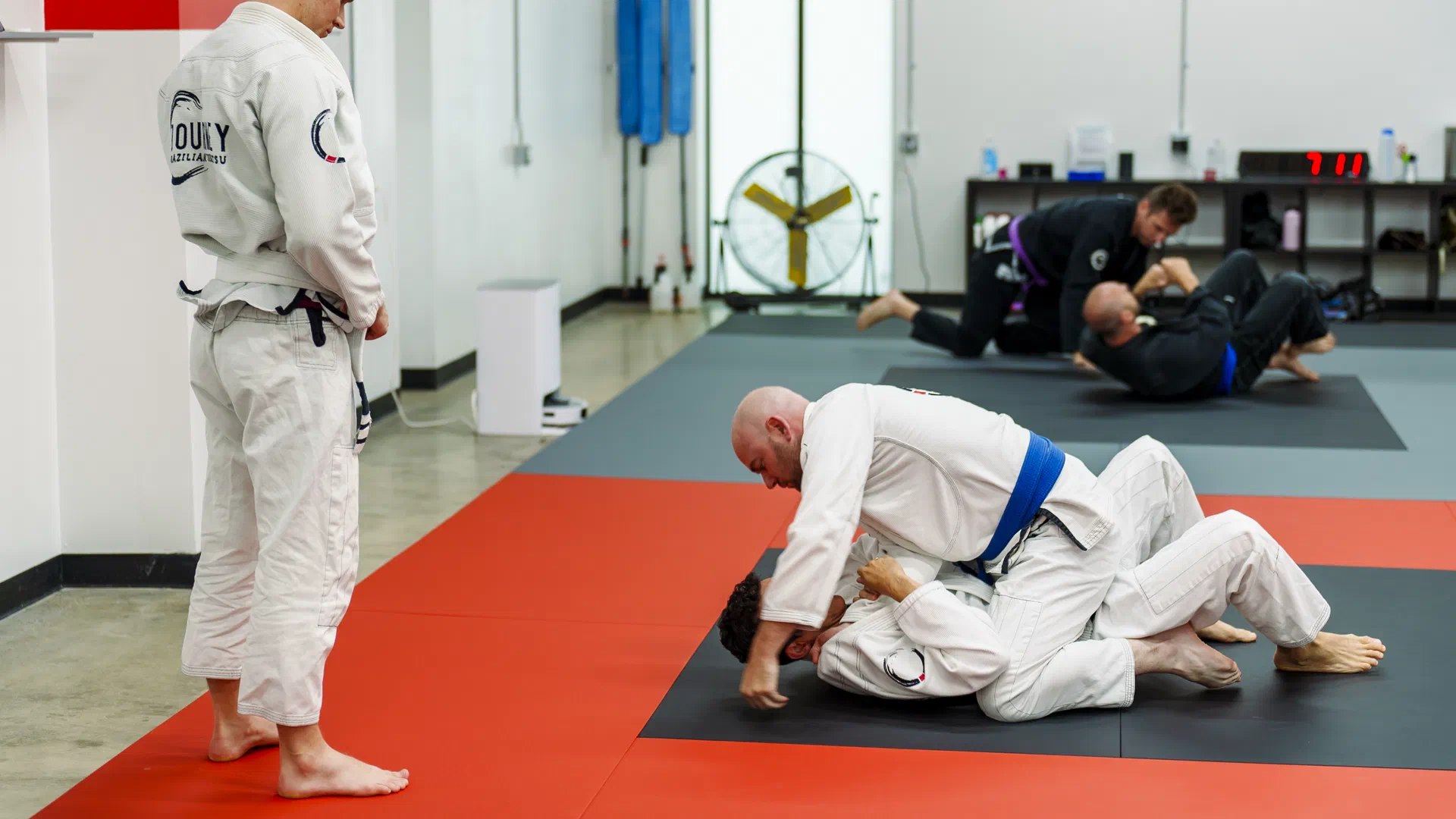 Adult BJJ community students working on the mat