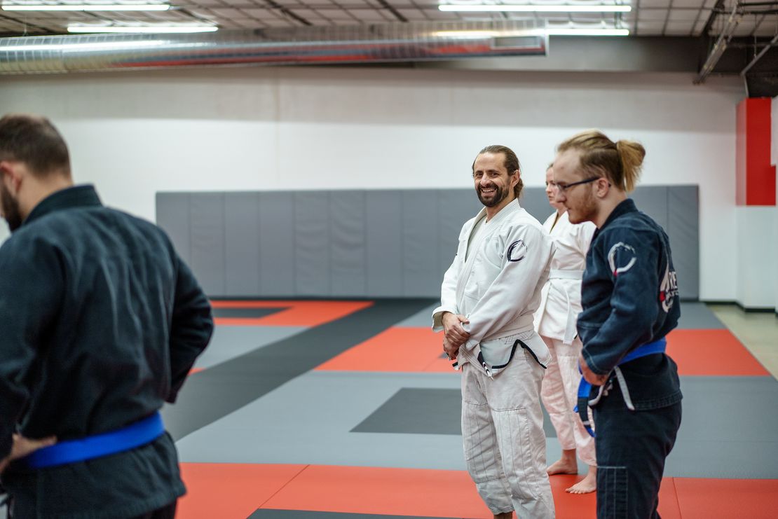 Happy adult BJJ student smiling at Journey Brazilian Jiu-Jitsu Academy in Madison