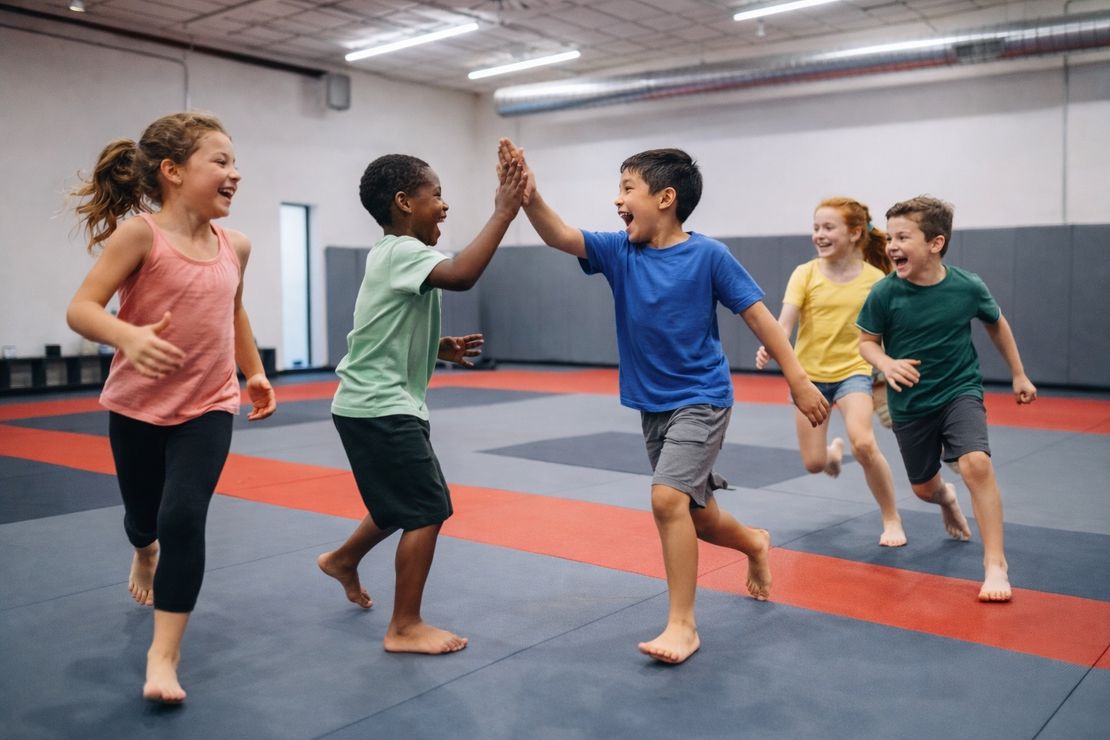 Kids high-fiving and celebrating at a birthday party at Journey BJJ Academy Madison WI