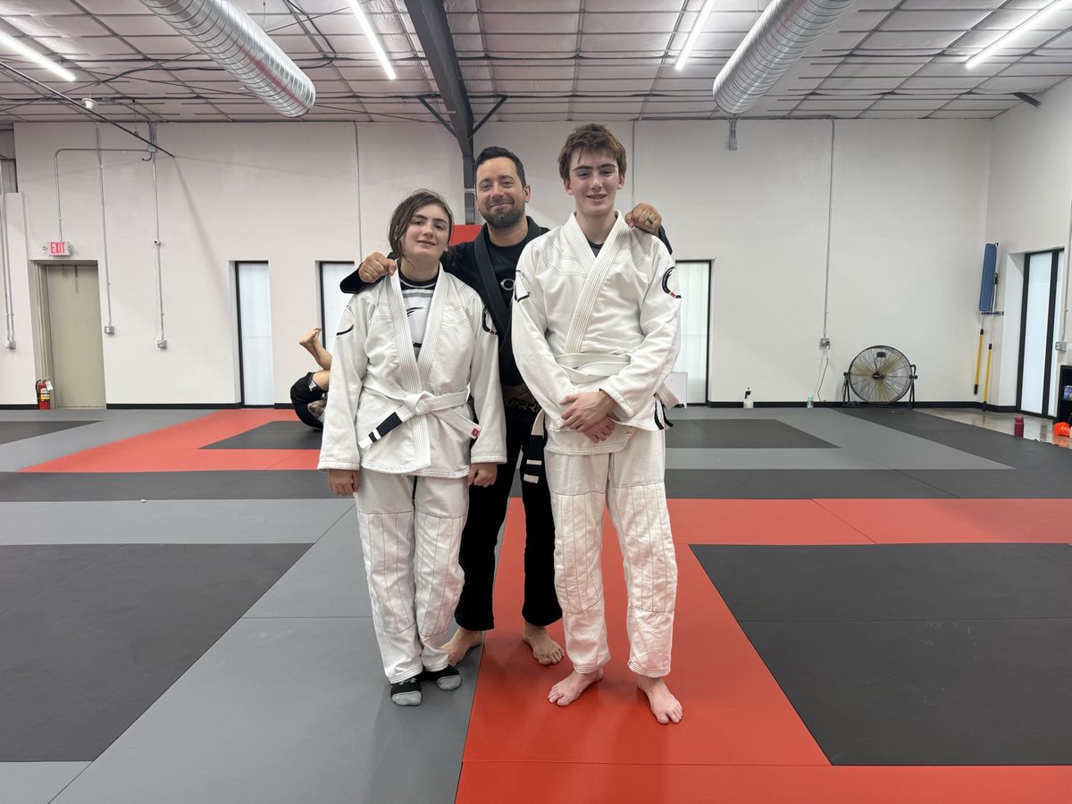 Coach Alex with two teen students at Journey Brazilian Jiu-Jitsu, an in-person third place