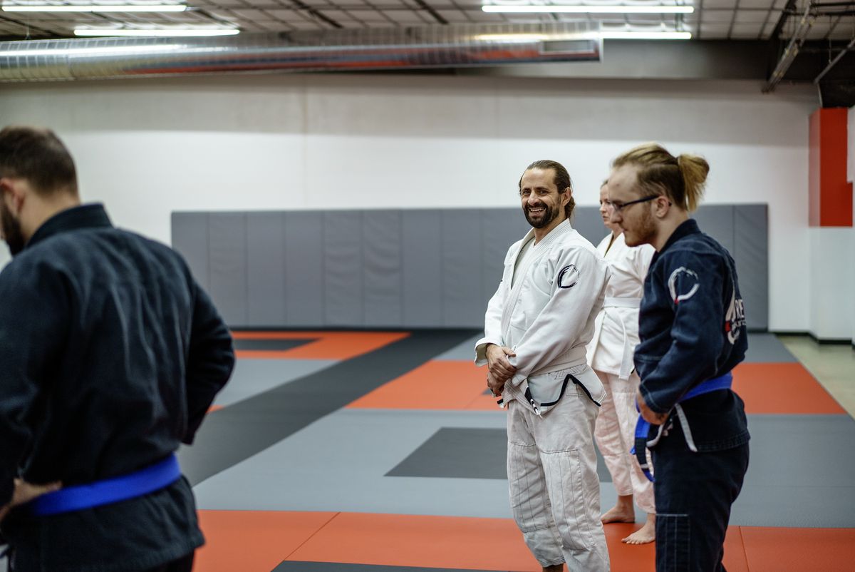 gi class group smiling blue belt students mat