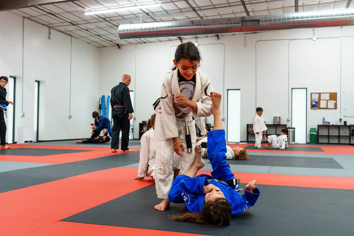 girl in white gi passing guard smiling