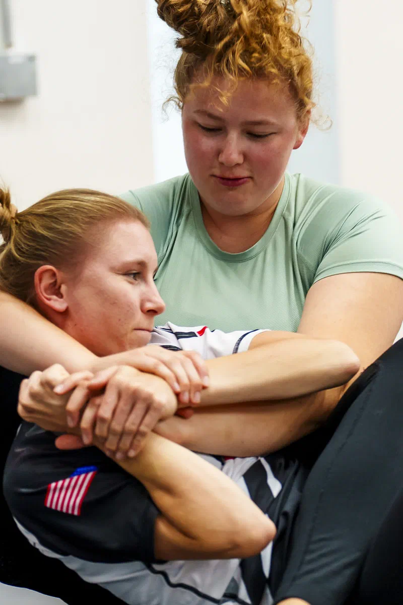 Women training submission techniques in Madison BJJ class
