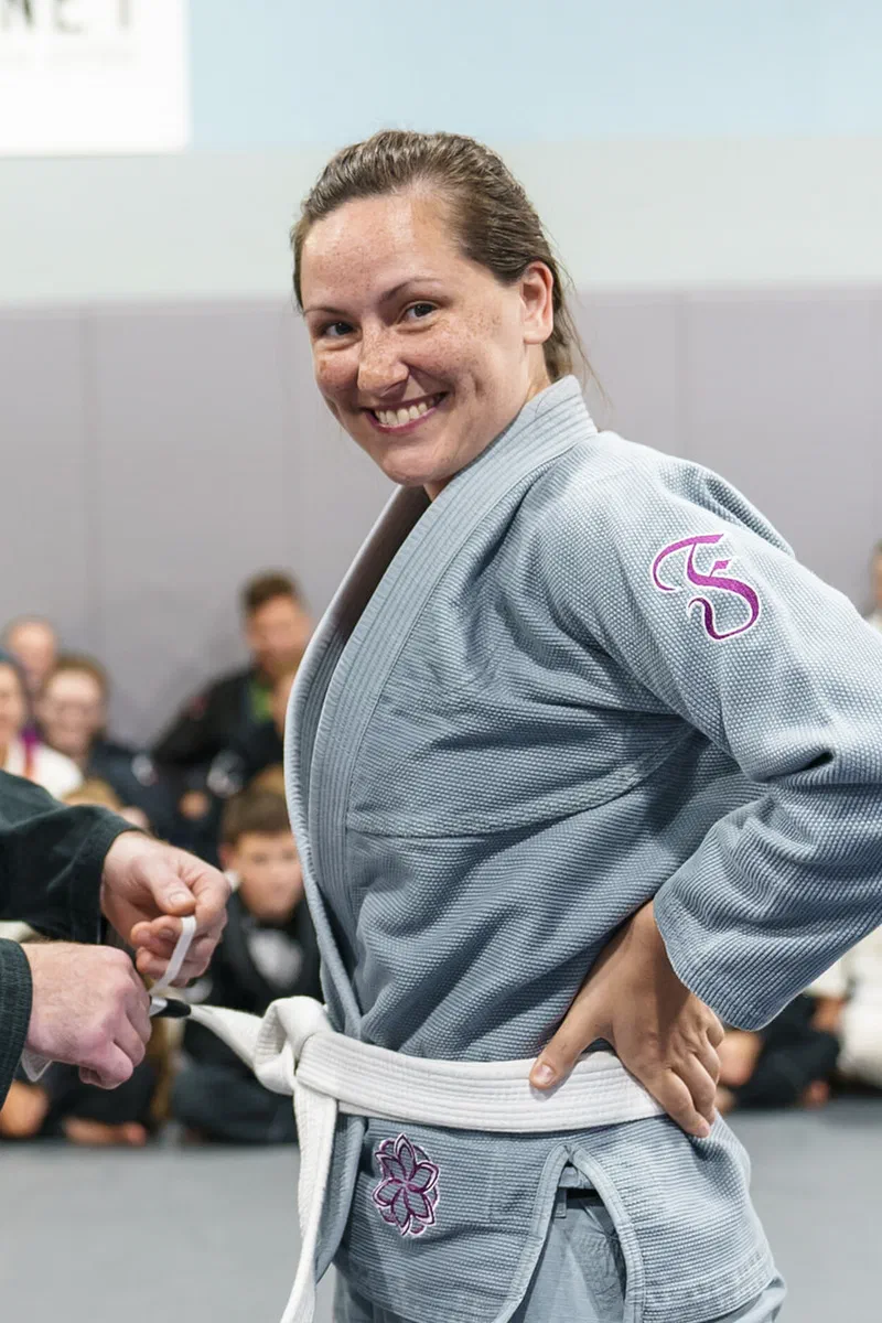 Woman receiving belt promotion at Journey BJJ Academy Madison
