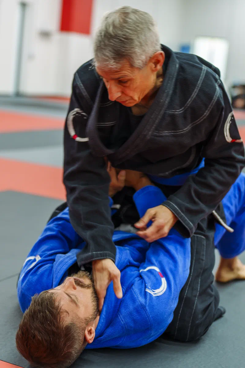 Adult BJJ community students working on the mat
