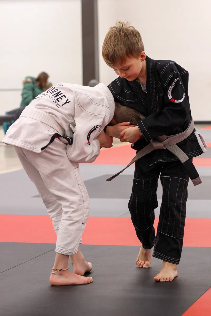 Kids sitting attentively learning Brazilian jiu jitsu in children's BJJ class in Madison, WI