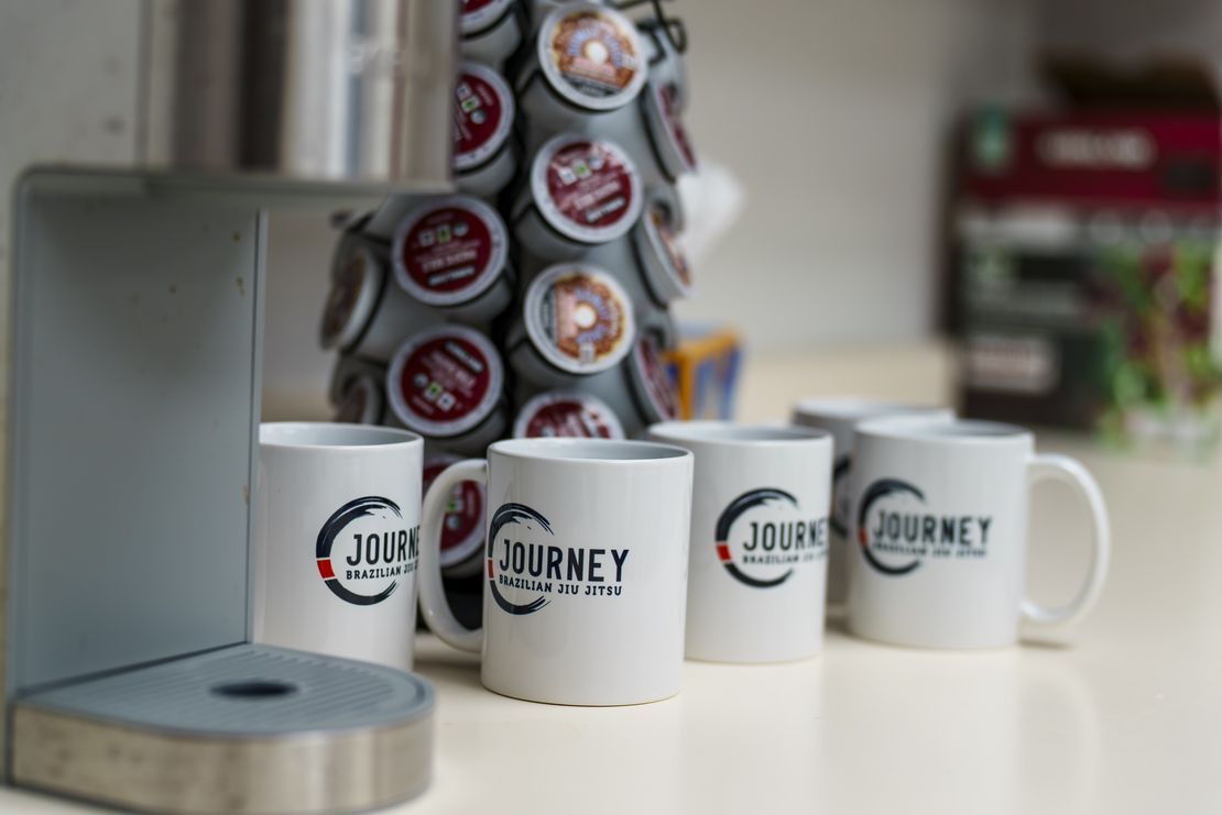Interior view of Journey BJJ Academy showing clean, modern facility with branded amenities
