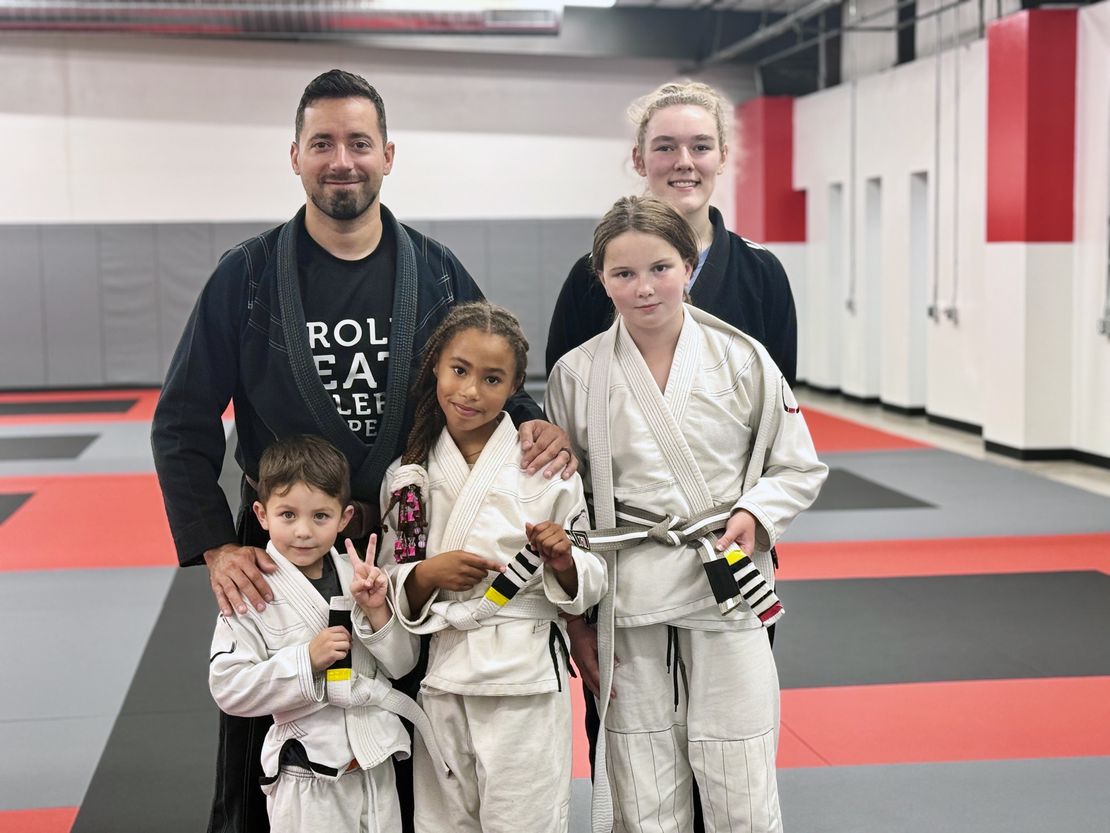 Coach Alex standing with newly promoted students