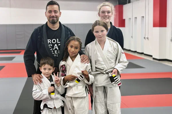 Coach Alex standing with kids students at Journey BJJ Madison