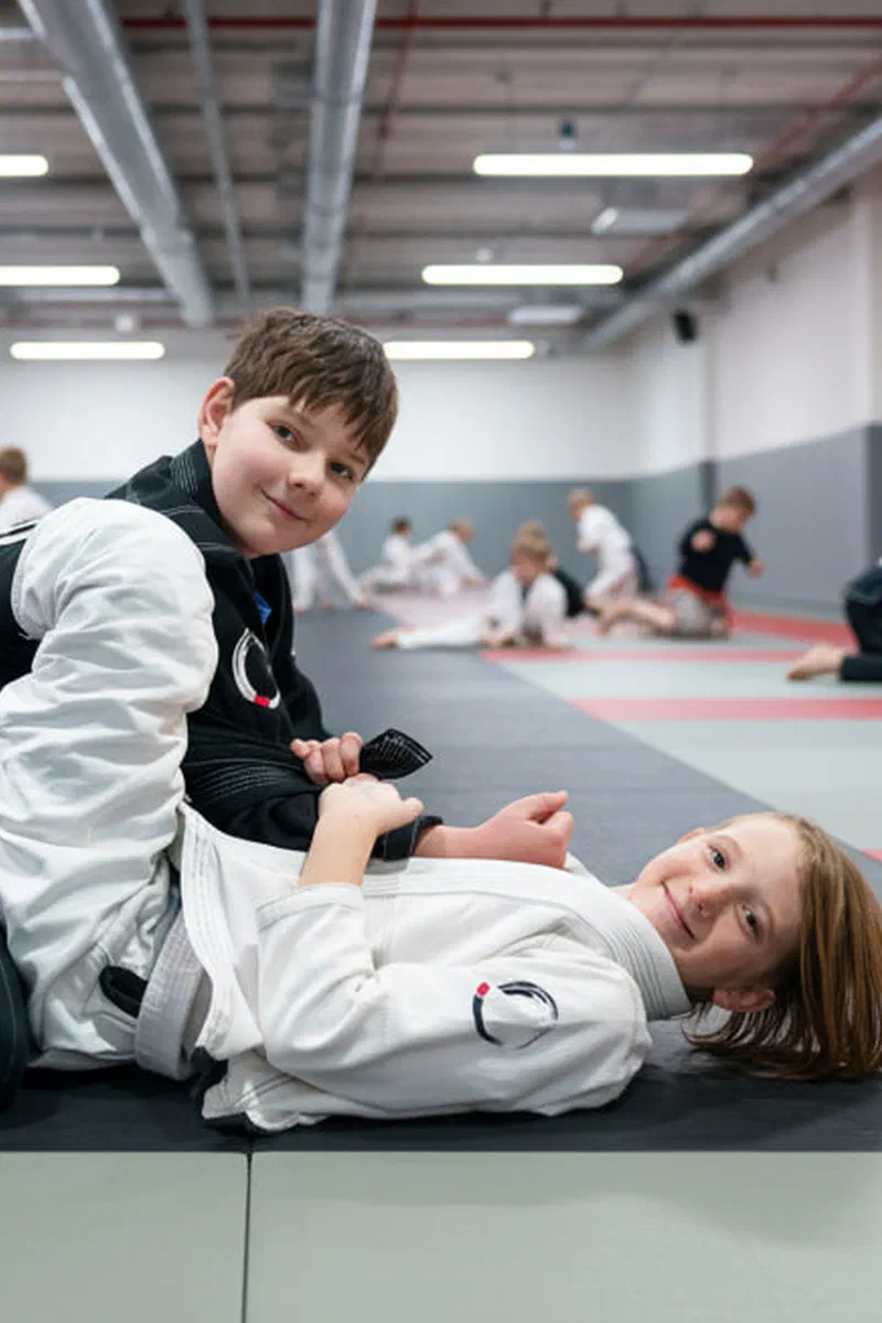 Coach Alex standing with newly promoted kids after belt ceremony