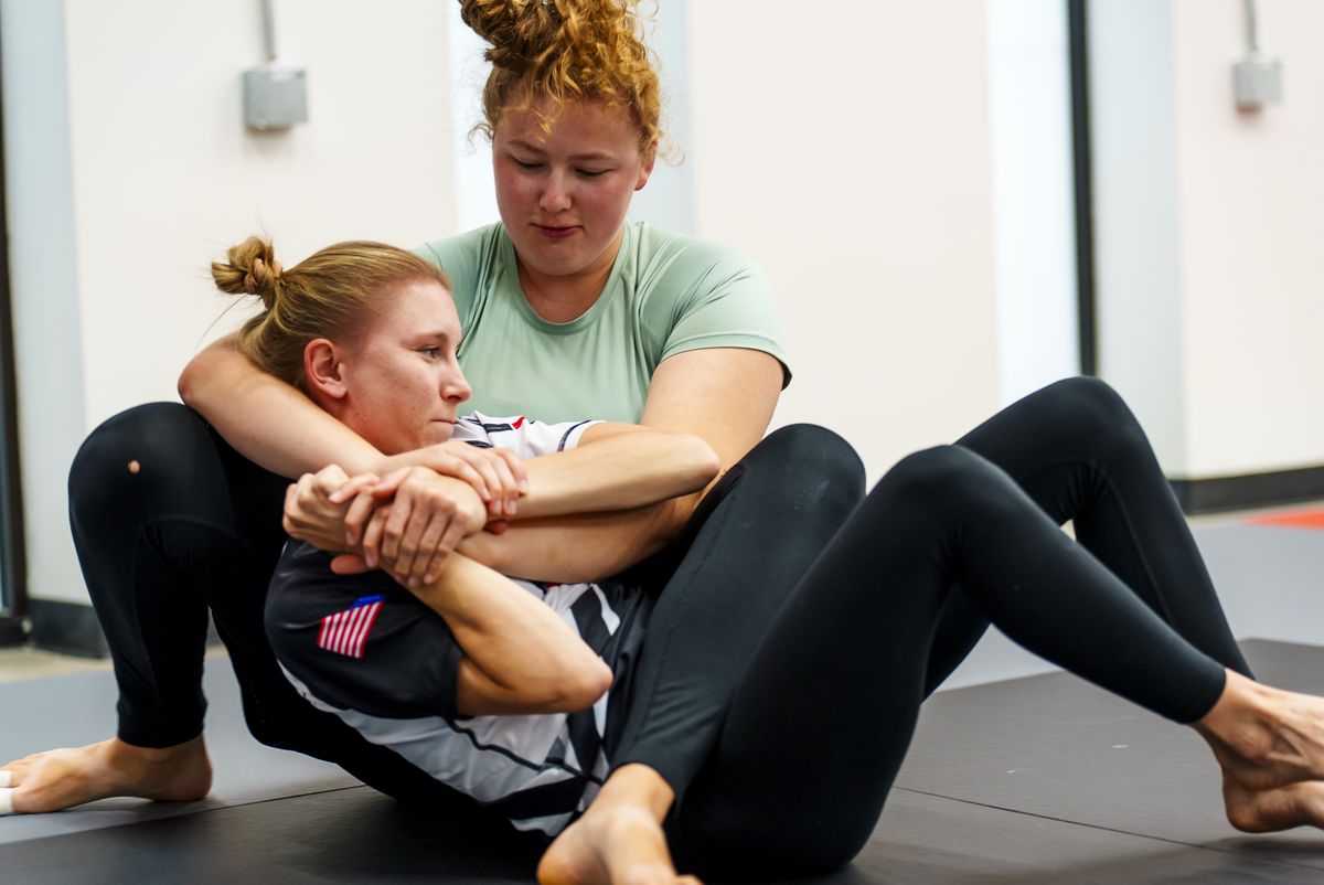 Two women drilling a rear-naked choke in no-gi class at Journey BJJ in Madison, WI.