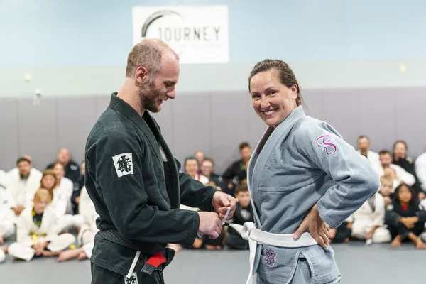 Woman being promoted at Journey BJJ Madison