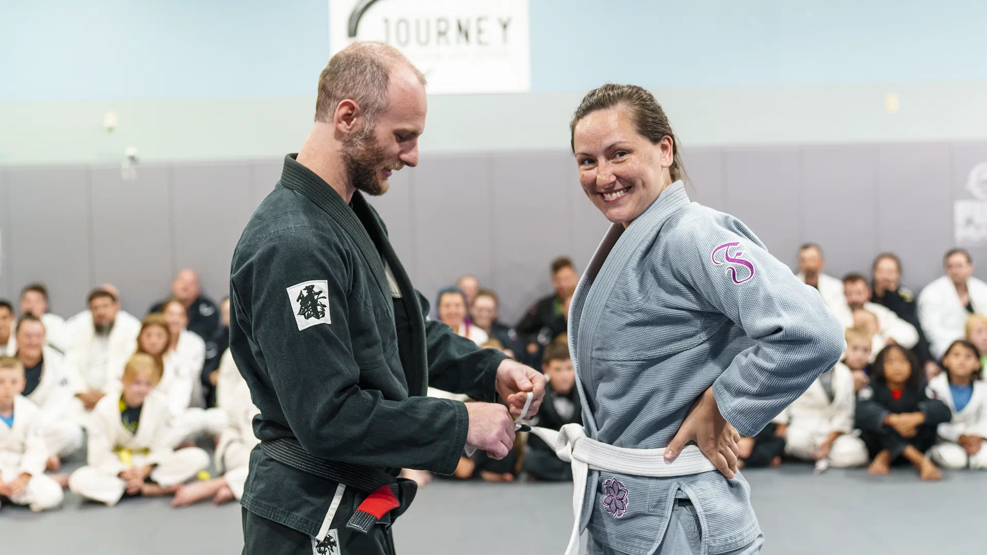 Woman receiving belt promotion at Journey BJJ Academy Madison
