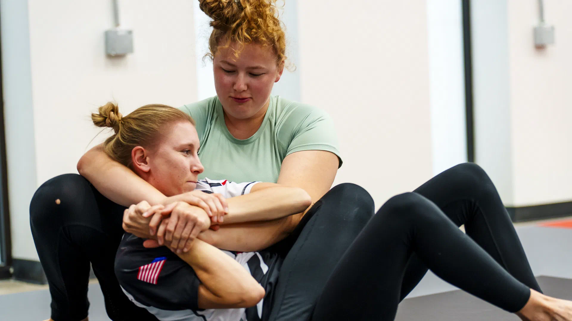 Women training submission techniques in Madison BJJ class
