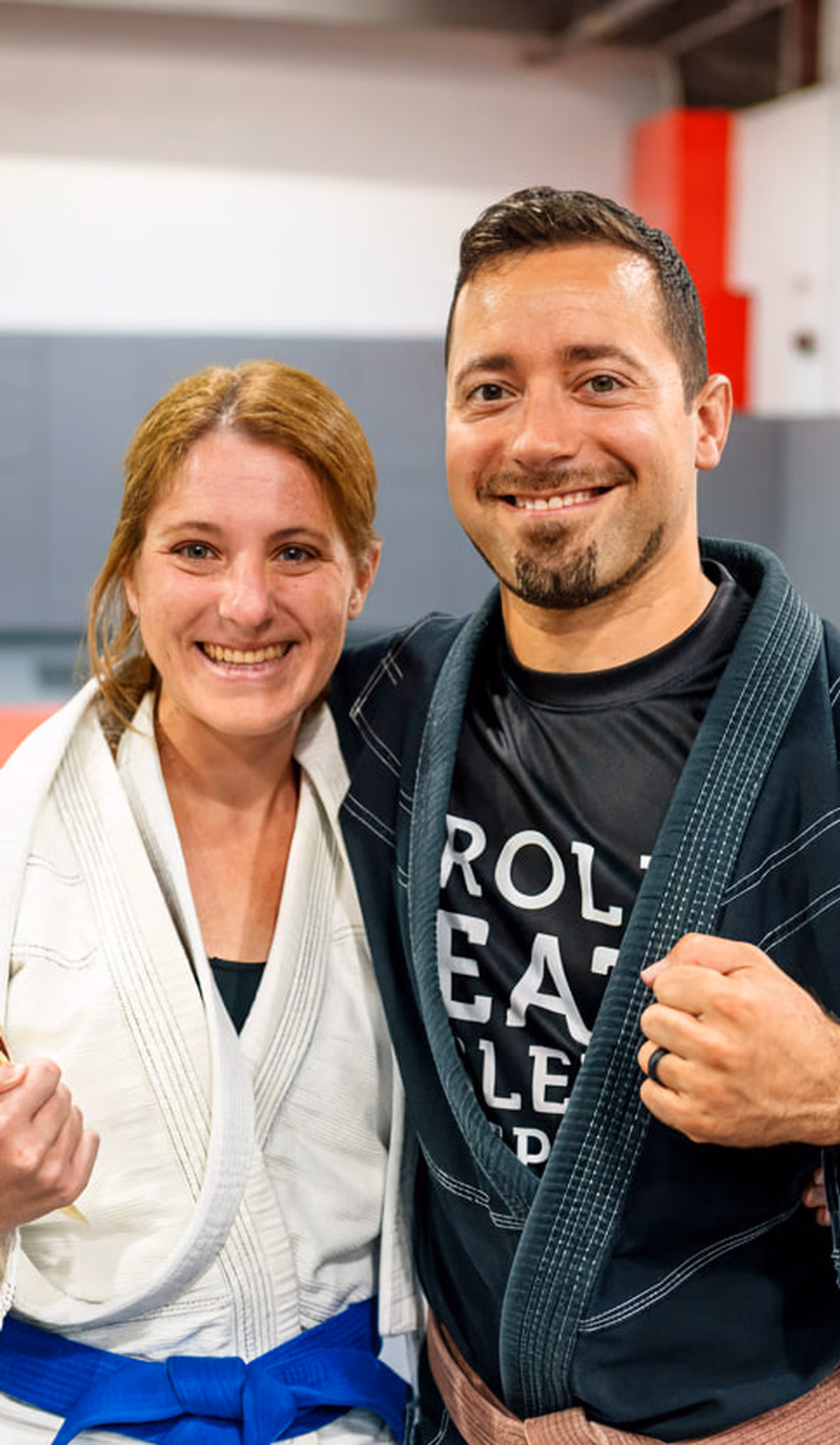 Brazilian Jiu-Jitsu coach standing with a student who was promotied