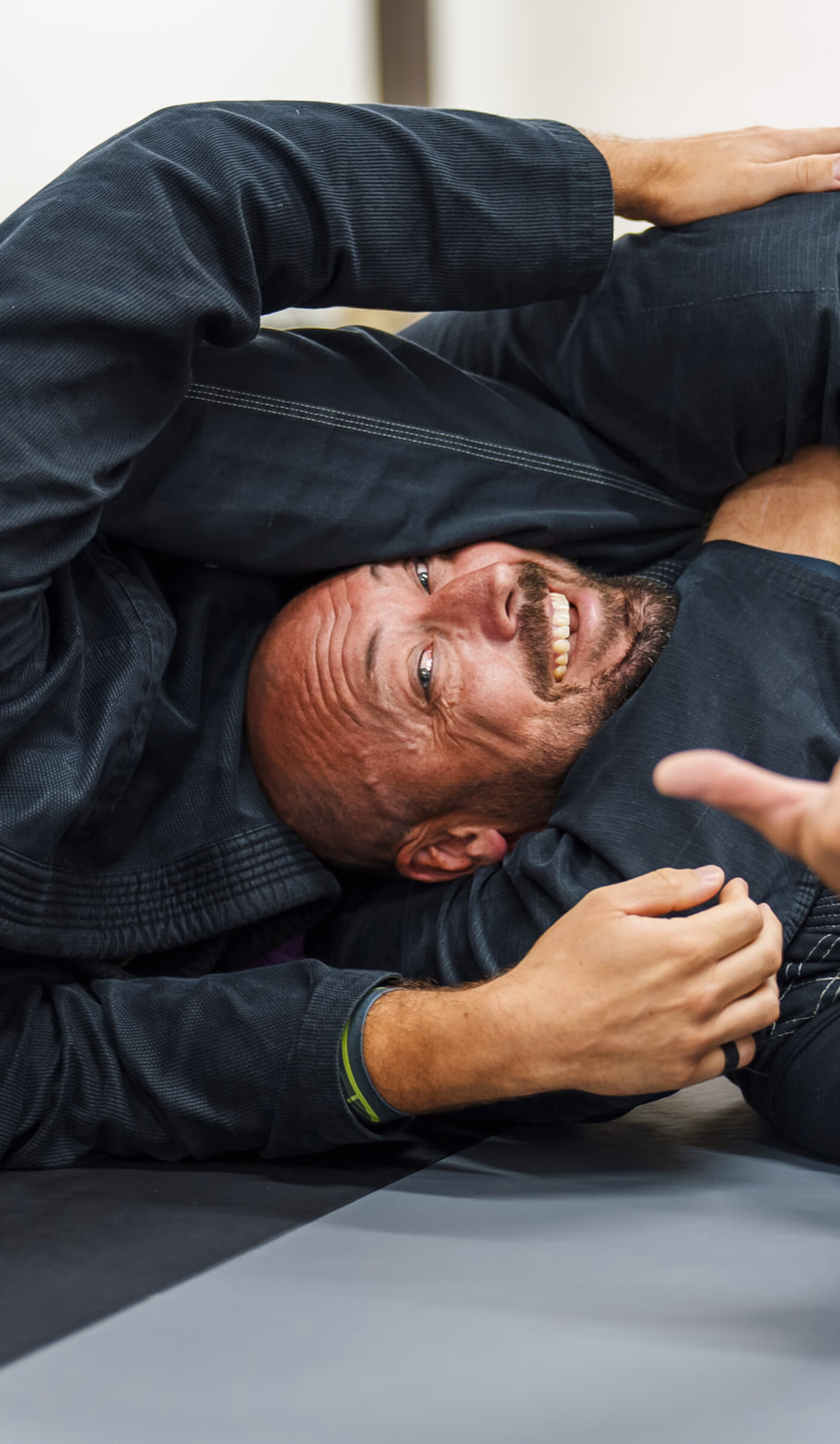 Brazilian Jiu-Jitsu student applying rear triangle technique to a laughing student at a Madison BJJ class.