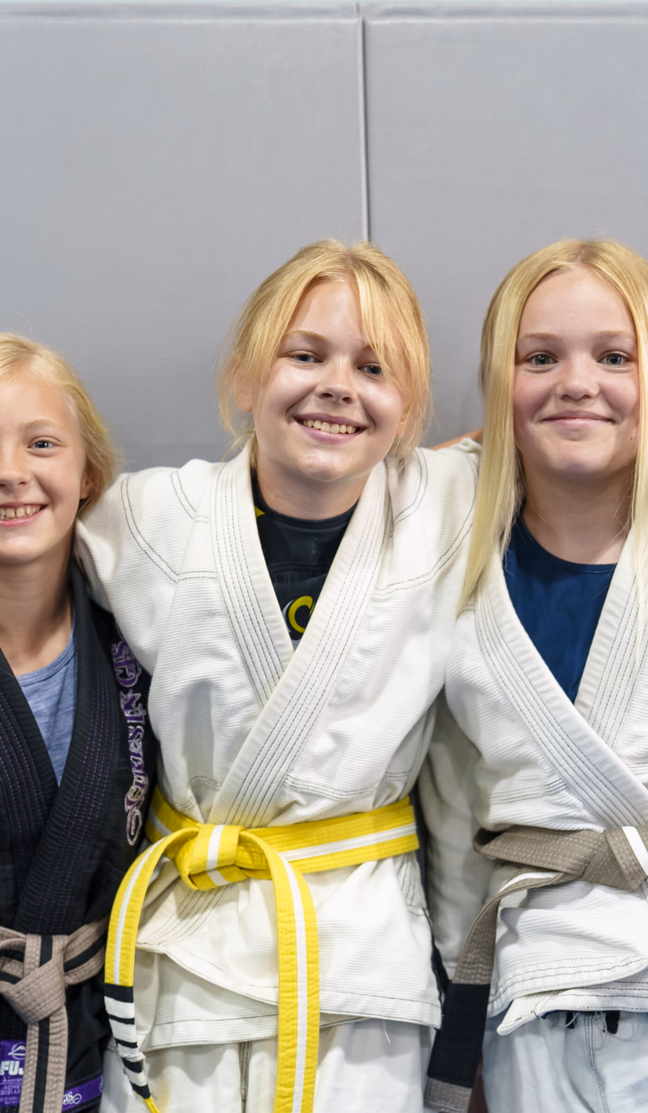 Kids sitting attentively learning Brazilian jiu jitsu in a children's BJJ class in Madison, WI